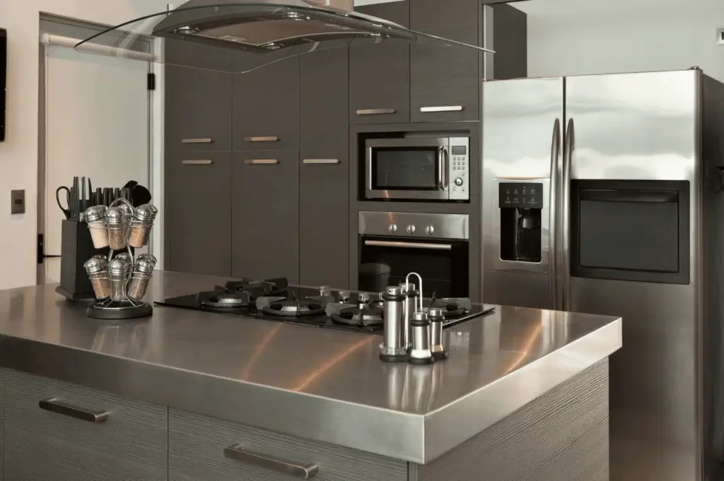 Sleek modern kitchen with dark wood cabinetry, stainless steel appliances, and a central island cooktop beneath a curved glass range hood; a minimalist, ergonomic space blending contemporary design with culinary functionality.