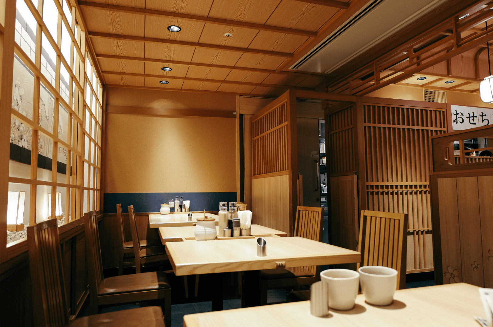 Japanese minimalist interior restaurant design showcasing warm wooden restaurant interior design elements and clean restaurant design principles, ideal for singapore restaurant design inspiration. This interior design blends smooth operations with a serene restaurant space for cooking and dining, suited for hotel venues or a modern house. The tables and subtle art pieces create a refined atmosphere admired in london and singapore, offering a warm welcome to customers. Thoughtful ideas for bar layout, location planning, and venue flow provide inspiration for hospitality projects. Soft lighting enhances the ambiance and decor, inviting guests to enjoy the life and ambience of excellent service. Designed to cater to family gatherings, the appealing style evokes a sense of calm, with tips to plan for offices, strengthen brand design, and encourage relax and reflect moments. Perfect for projects, galleries, and accessibility upgrades, the journey through dim lighting, high functionality, and fine details celebrates architecture and nature. Efficient operations, good ventilation, and subtle plants achieve balance and flow, helping to opt the form for the world's best dining experiences. Encourages visit and stimulates appetite, with ramps for inclusivity, understanding of mistakes to avoid, and consideration for disabilities to prevent delays. The kitchen layout is important for ideal comfort of staff, with an open place concept that elevates the dining experience.