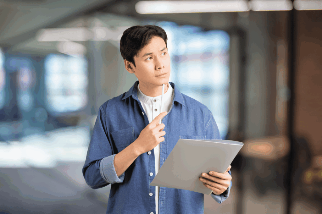 Person reviewing a clipboard in a modern building, thinking through contractor options for a restaurant renovation