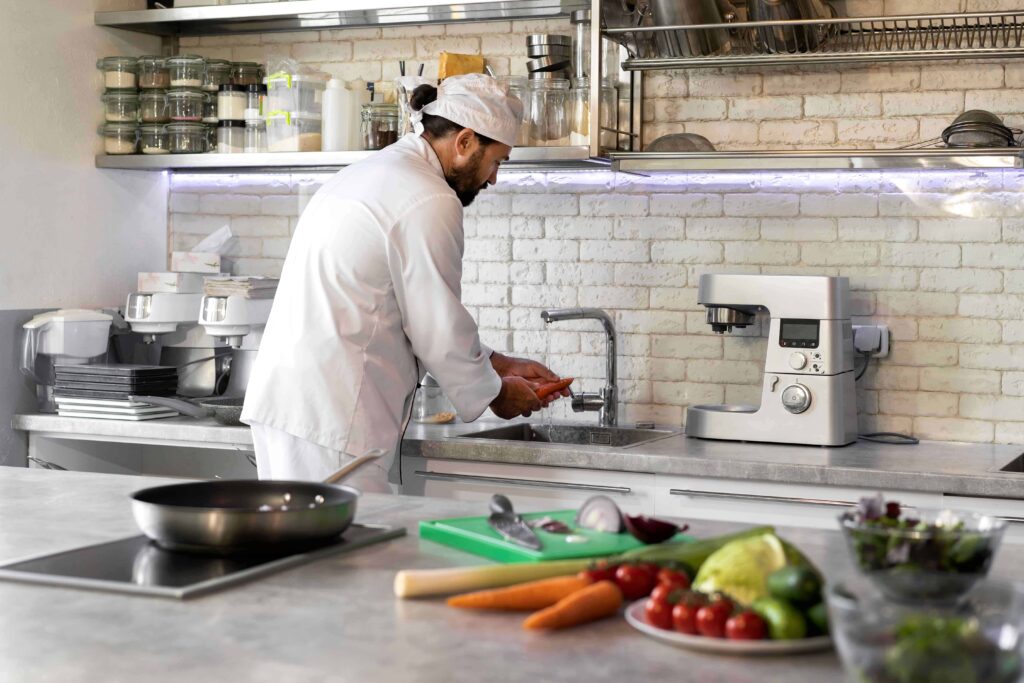 A picture of a chef working in a clean kitchen free from any bacteria that may harm the restaurant and diner.
