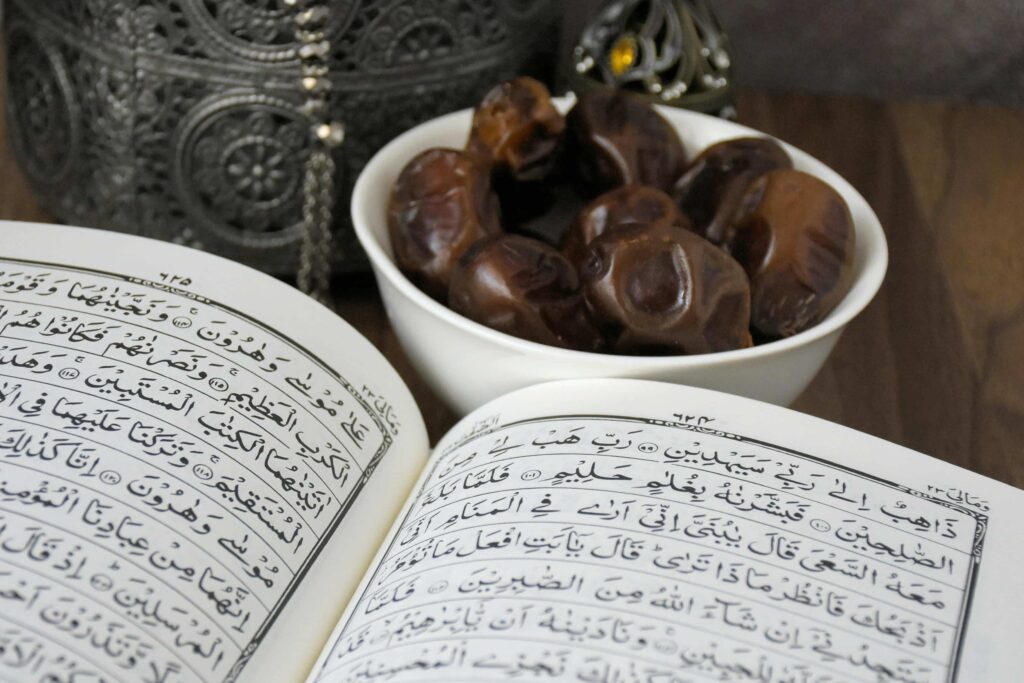 An image of a Halal food on a white bowl, accompanied by a Quran sitting on a wooden table.