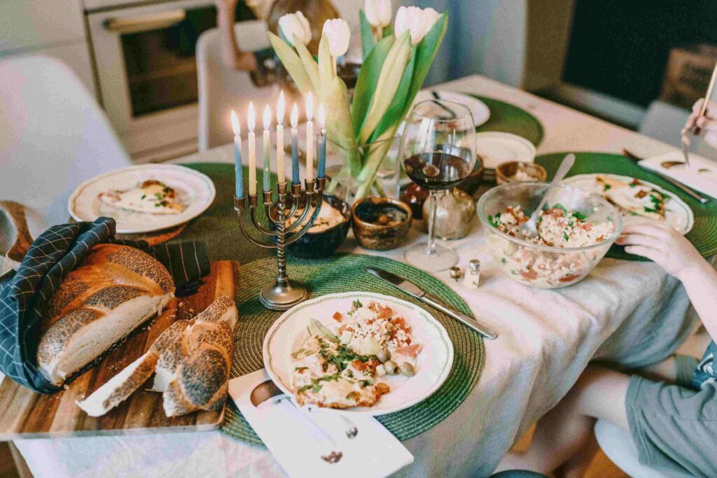 An image of a religious table complete with the Menorah and food in line with it.