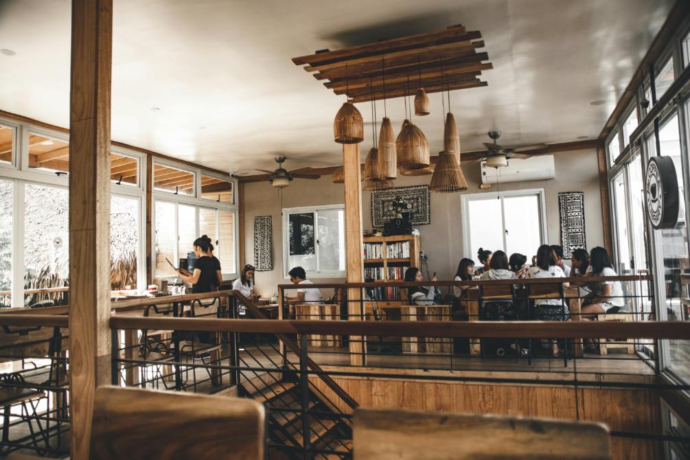 A photo of a busy dining area laced with intricate woodwork design as it envelopes the design.
