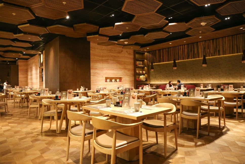 A photo of a restaurant's interior with warm lighting and laced with a modern wooden design schemes.