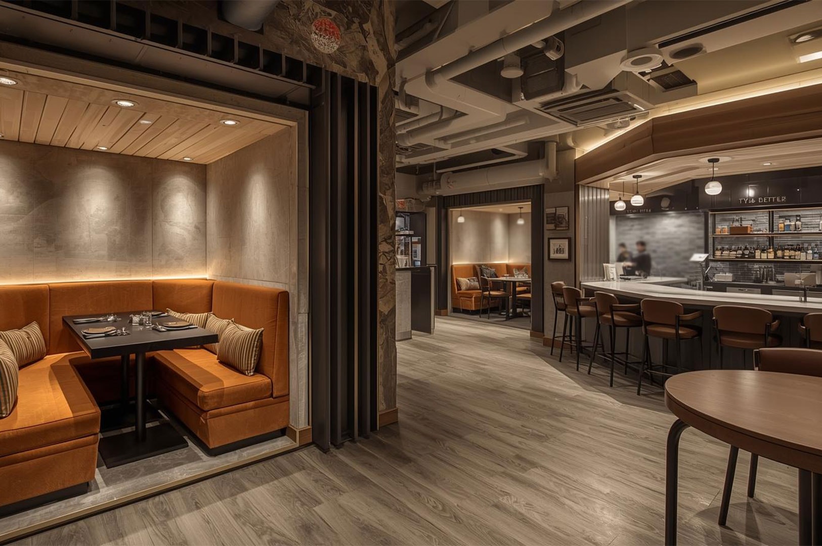 A spacious restaurant interior featuring an industrial design with exposed ceiling pipes, cozy orange booth seating, wooden floors, and a well-lit bar counter area.