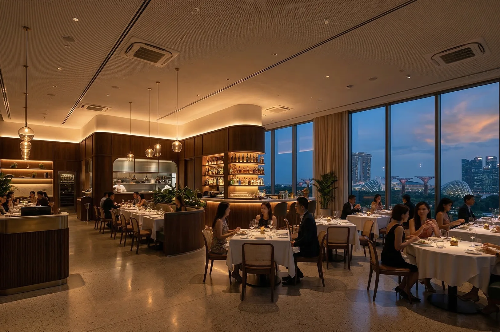An upscale fine dining restaurant in Singapore featuring floor-to-ceiling windows with a sunset view of Marina Bay Sands and Gardens by the Bay.