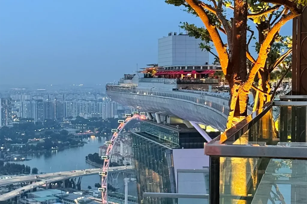 Panoramic dusk view from Marina Bay Sands Sands SkyPark showing Singapore Flyer and skyline near LAVO