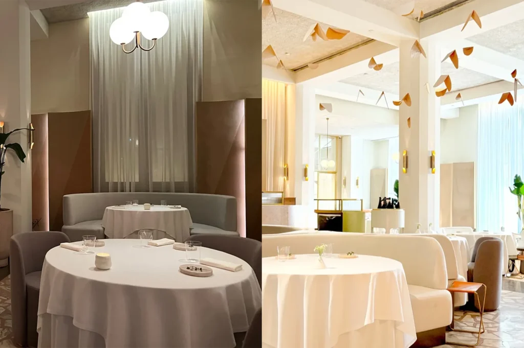 Elegant fine dining room layout at Odette restaurant featuring round white tablecloth dining tables, plush curved booths, and modern art light fixtures.