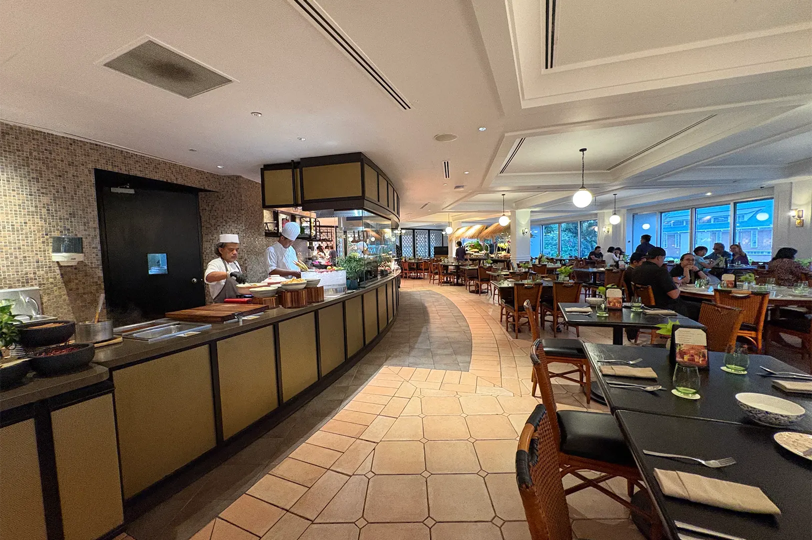 Spacious interior dining hall and live cooking station at Asian Market Cafe in Fairmont Singapore.