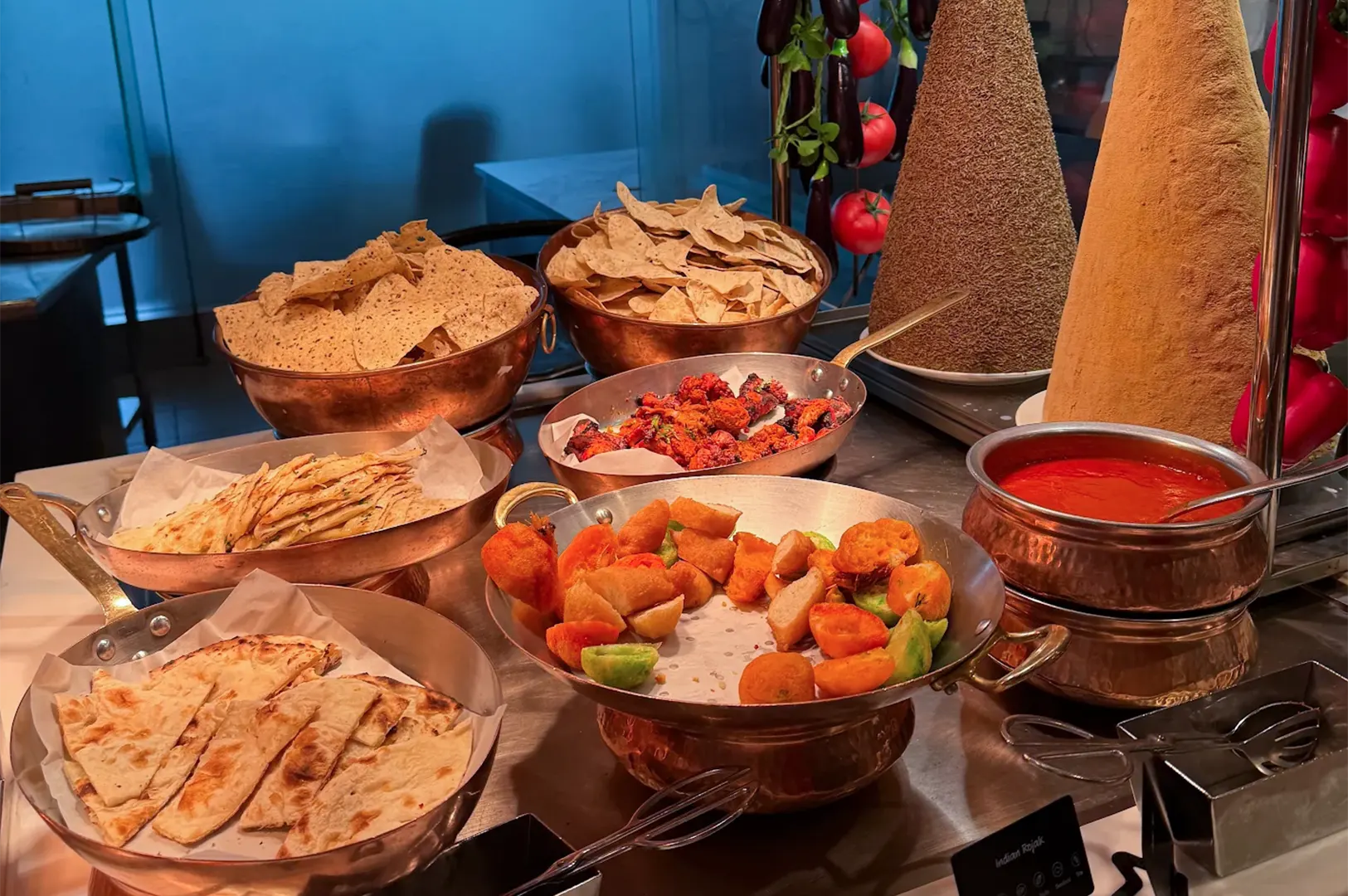 Assortment of Indian flatbreads, crispy papadum, and fried appetizers at the Indian buffet station in Shangri-La Singapore.