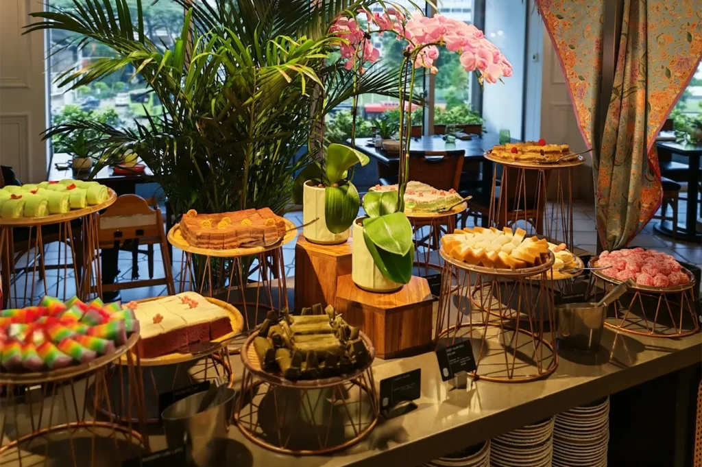 Assorted Nyonya kueh and traditional Asian desserts displayed on tiered stands at Asian Market Cafe.