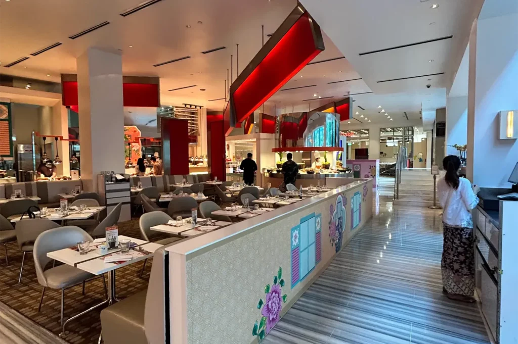 Spacious and modern restaurant interior with elegant dining tables, booth seating, and red lighting at Shangri-La Singapore.