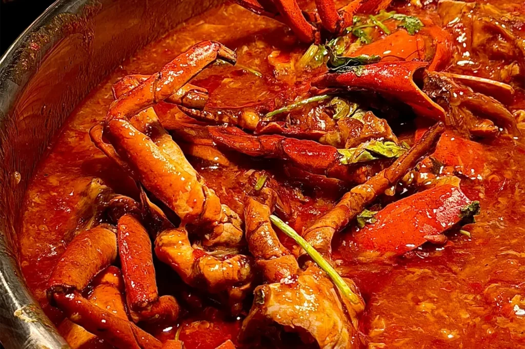 Close-up of fresh Singapore chili crab cooked in rich savory spicy gravy at Asian Market Cafe buffet.