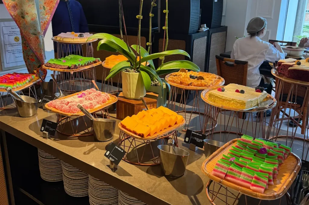 Colorful Peranakan kuih, cakes, and sweet delicacies featured at the Asian Market Cafe buffet counter.